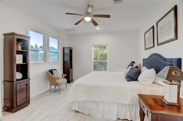 bedroom featuring light wood-type flooring, multiple windows, and ceiling fan