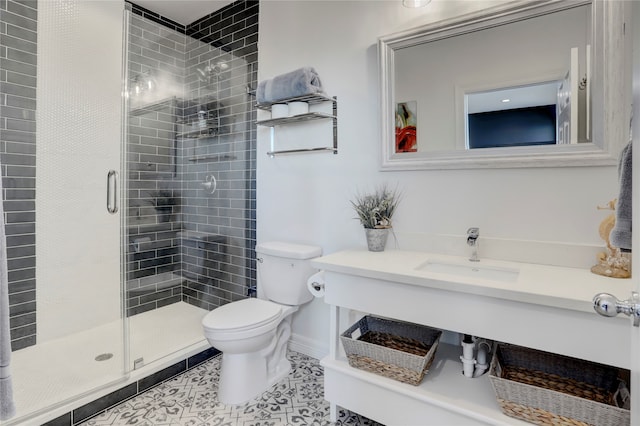 bathroom featuring tile patterned floors, a shower with door, vanity, and toilet