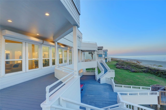 deck at dusk featuring a water view