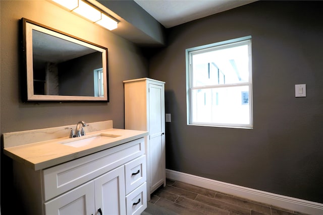 bathroom with vanity, a wealth of natural light, and hardwood / wood-style flooring