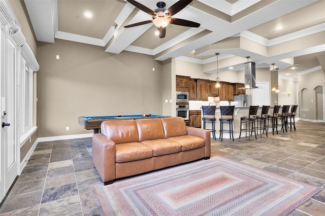 living room with coffered ceiling, beamed ceiling, ornamental molding, and ceiling fan