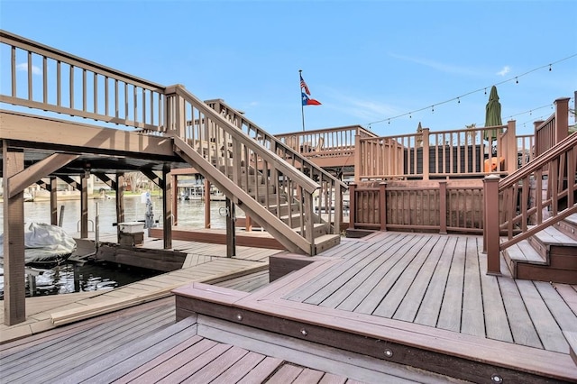 wooden deck featuring a dock and a water view