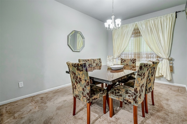 dining space featuring light carpet and an inviting chandelier