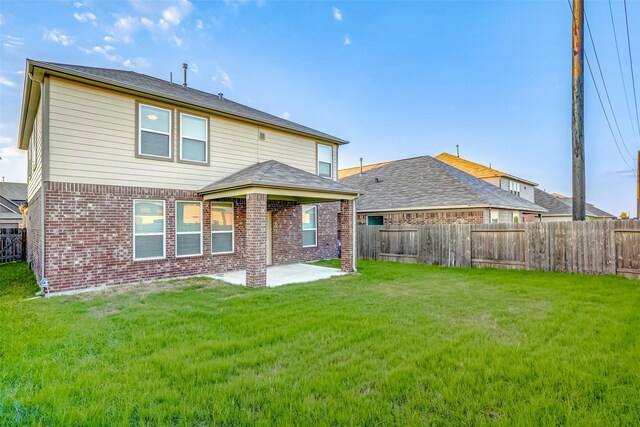 back of property featuring a yard and a patio area