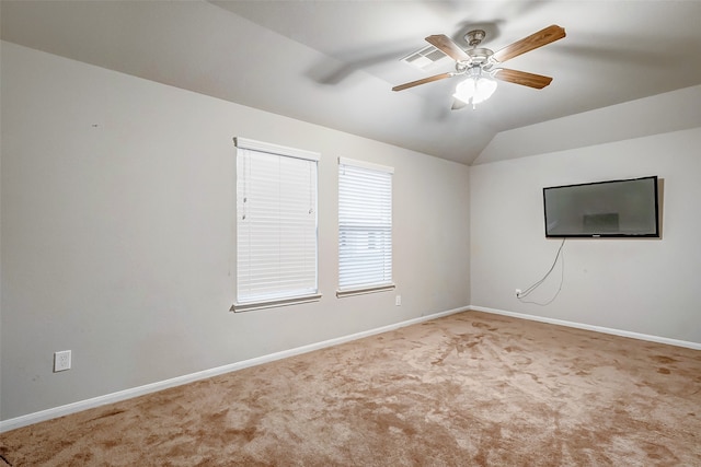 spare room with ceiling fan, lofted ceiling, and light carpet