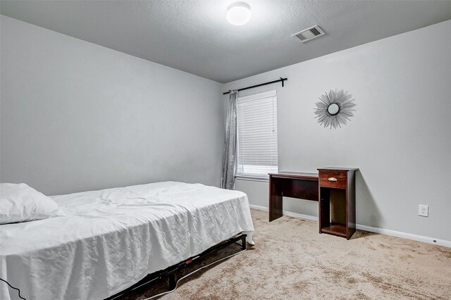 bedroom featuring a textured ceiling and carpet floors