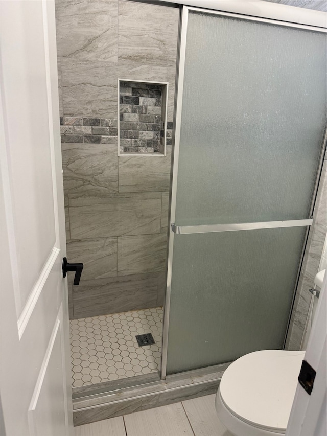 bathroom with walk in shower and toilet