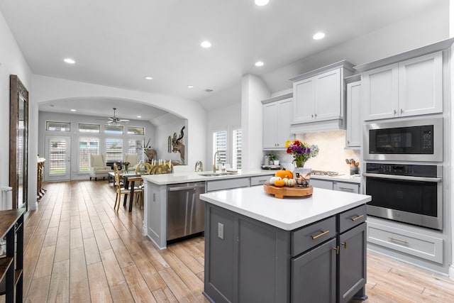 kitchen featuring a center island, sink, kitchen peninsula, light hardwood / wood-style flooring, and appliances with stainless steel finishes