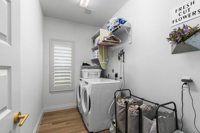 washroom with separate washer and dryer and hardwood / wood-style flooring