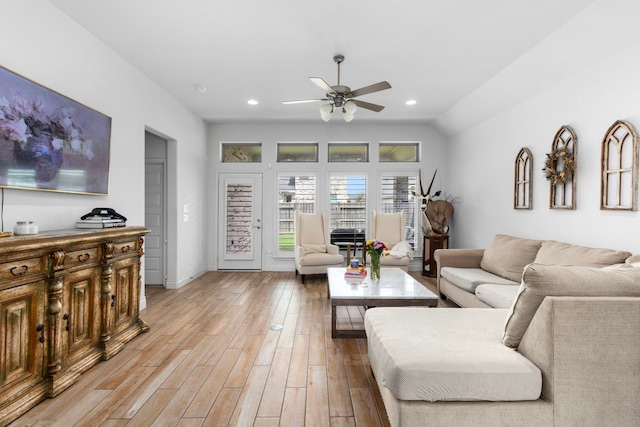 living room with light hardwood / wood-style flooring, vaulted ceiling, and ceiling fan