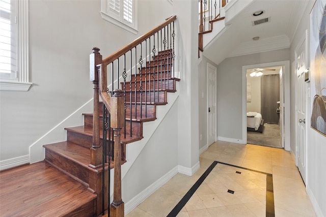 interior space with tile patterned flooring, ornamental molding, and ceiling fan