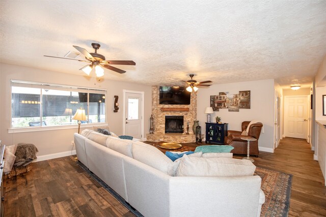 living room featuring a textured ceiling, dark wood-type flooring, and a wealth of natural light