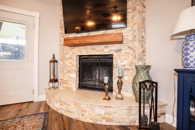 interior details with hardwood / wood-style flooring and a stone fireplace