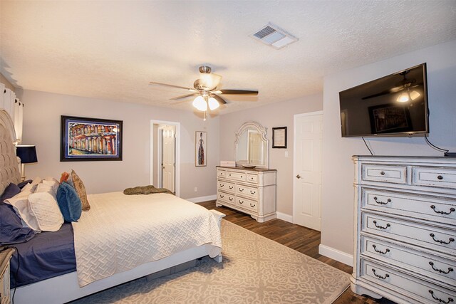 bedroom featuring a textured ceiling, ceiling fan, and dark hardwood / wood-style floors