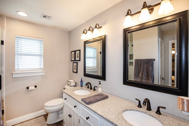 bathroom featuring vanity, a textured ceiling, and toilet