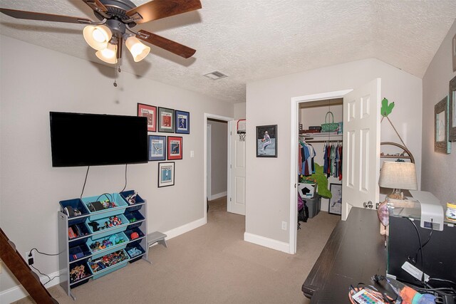 home office with light carpet, a textured ceiling, vaulted ceiling, and ceiling fan