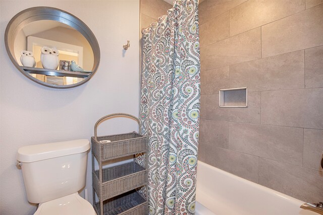 bathroom featuring toilet and shower / tub combo with curtain