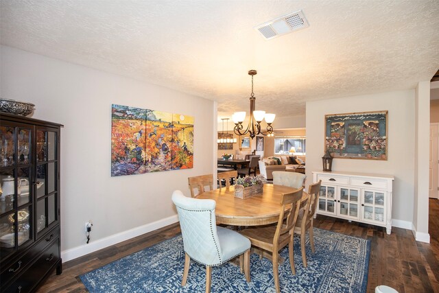 dining room featuring a chandelier, a textured ceiling, and dark hardwood / wood-style floors