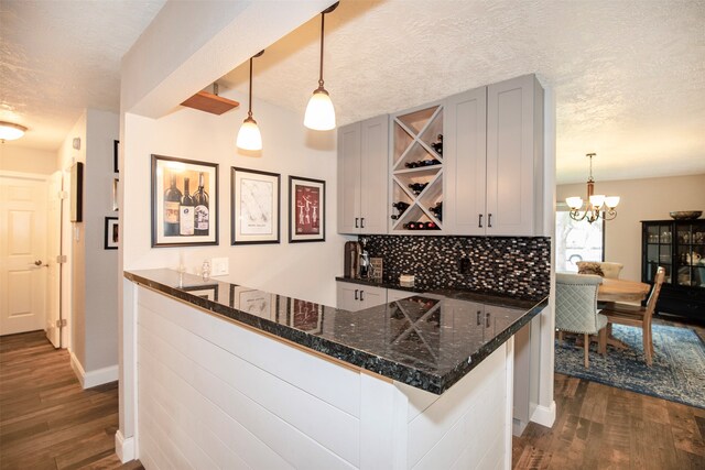 bar with gray cabinetry, dark hardwood / wood-style flooring, and pendant lighting