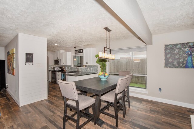 dining space with a textured ceiling, dark wood-type flooring, and sink