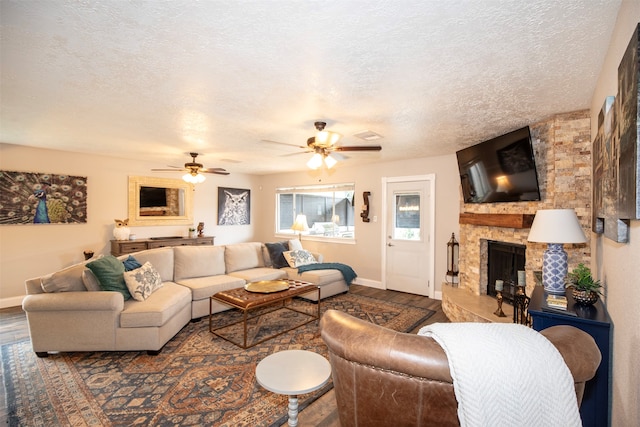 living room featuring a textured ceiling, wood-type flooring, and a fireplace