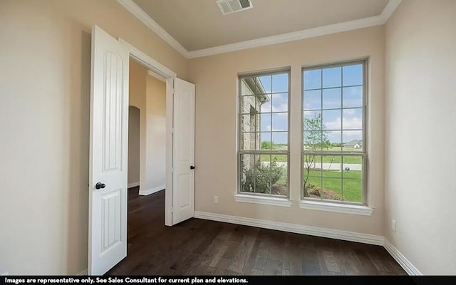 empty room with ornamental molding, plenty of natural light, and dark wood-type flooring