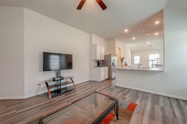 living room featuring light hardwood / wood-style floors, ceiling fan, and sink