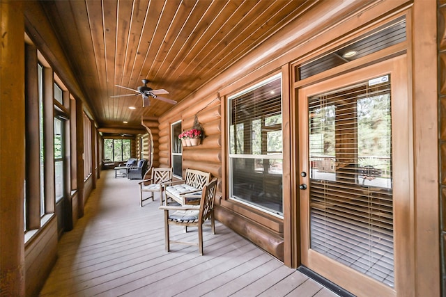 sunroom with ceiling fan and wooden ceiling