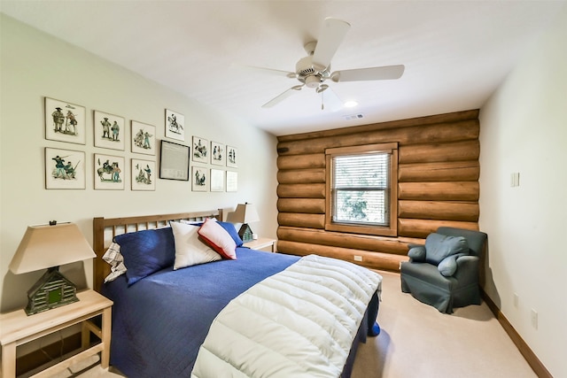 bedroom featuring ceiling fan, rustic walls, and carpet