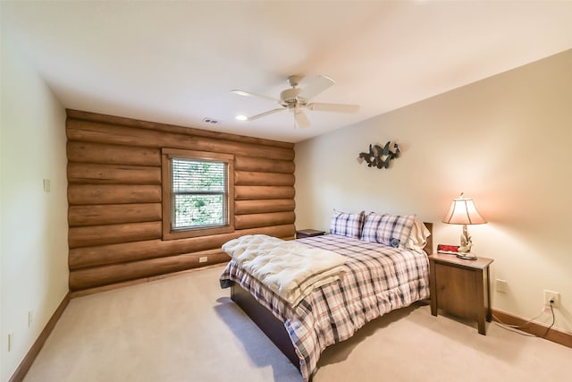 carpeted bedroom featuring ceiling fan and rustic walls