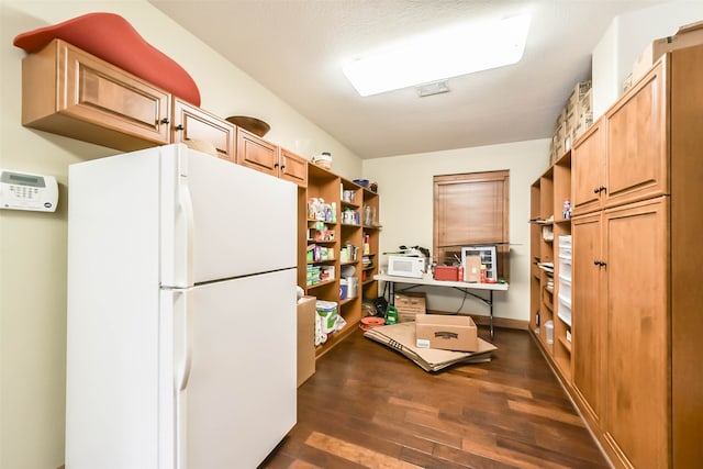 kitchen featuring a textured ceiling, dark hardwood / wood-style floors, and white appliances