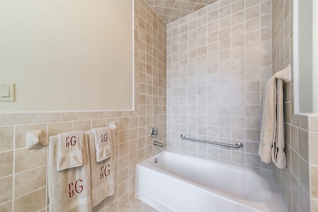 bathroom featuring tile walls and a washtub