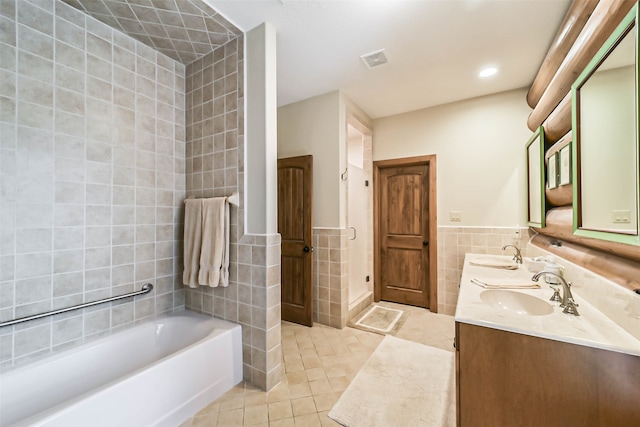 bathroom featuring vanity, tile walls, a bathtub, and tile patterned floors