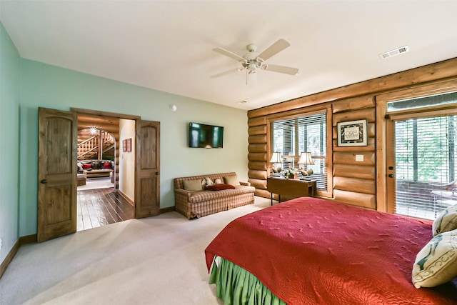 bedroom with hardwood / wood-style floors, ceiling fan, and rustic walls