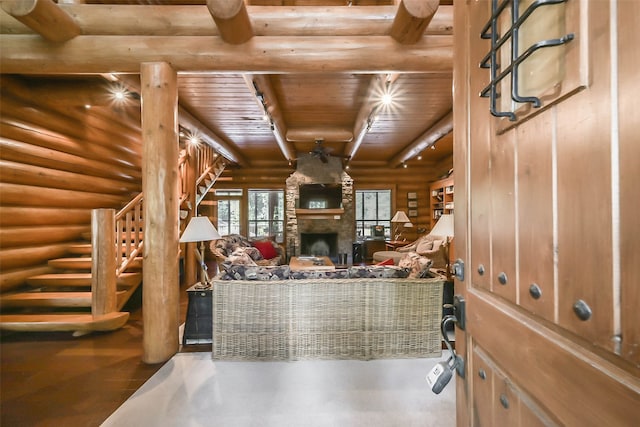 living room featuring wood ceiling, hardwood / wood-style flooring, log walls, and a stone fireplace