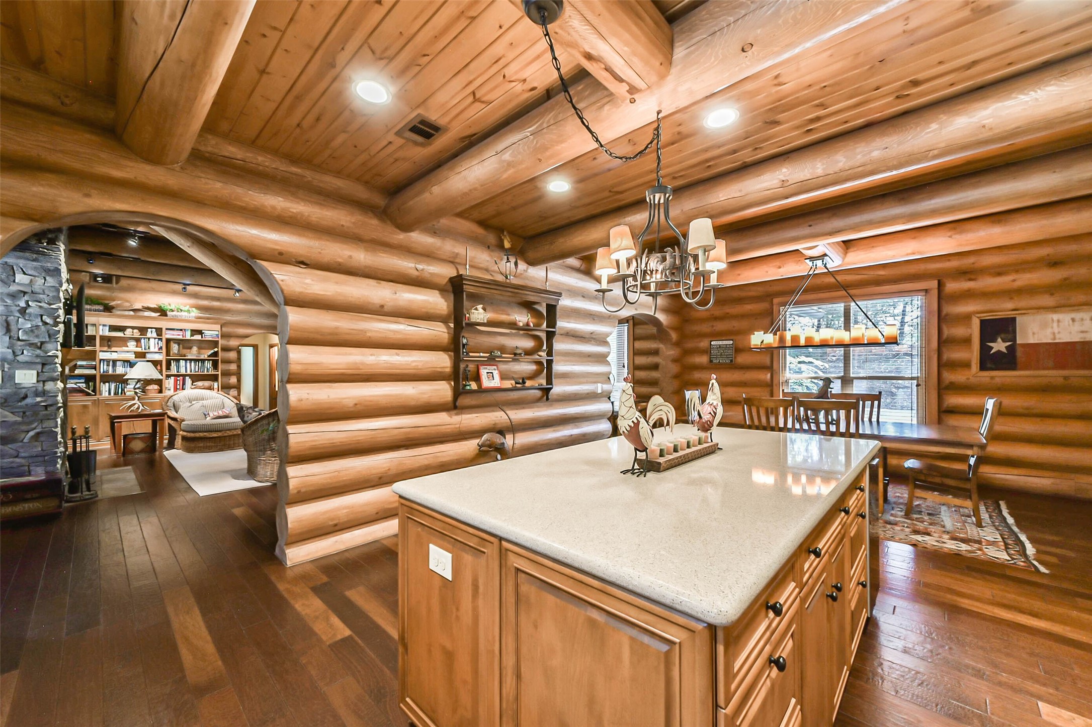 kitchen with dark hardwood / wood-style flooring, beamed ceiling, pendant lighting, wooden ceiling, and rustic walls