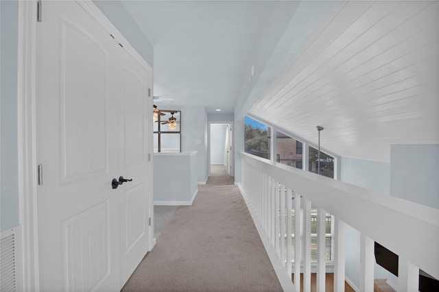 hall with wood ceiling, light carpet, and vaulted ceiling