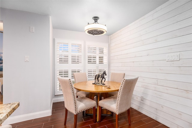 dining area featuring wooden walls