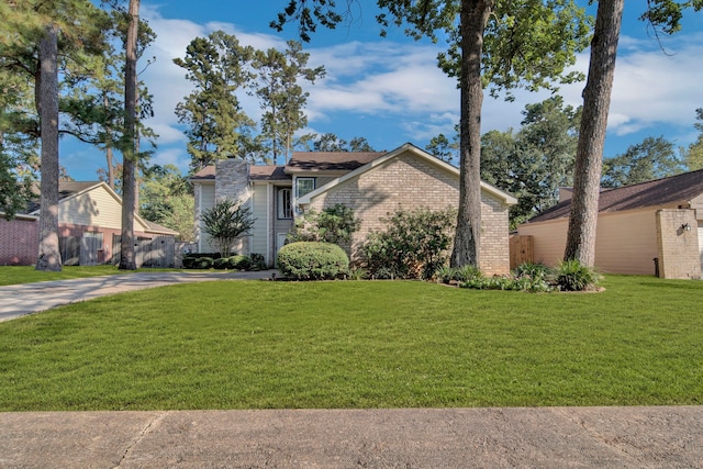 15010 Rolling Oaks Dr, Houston, TX 77070 - mid-century modern home featuring a front yard, brick siding, and concrete driveway