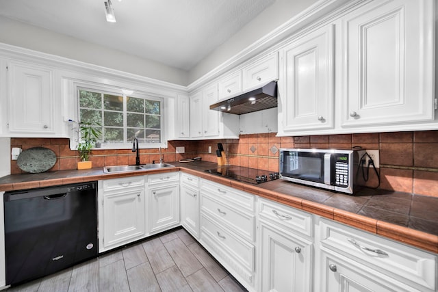 kitchen with tile counters, sink, white cabinets, decorative backsplash, and black appliances