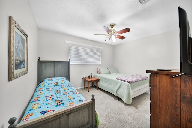 bedroom featuring ceiling fan, light colored carpet, and a textured ceiling