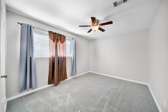 spare room with ceiling fan and light colored carpet