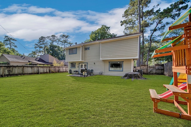 rear view of property featuring a playground, a yard, central AC unit, and a patio area