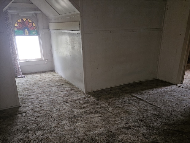 corridor featuring vaulted ceiling and carpet