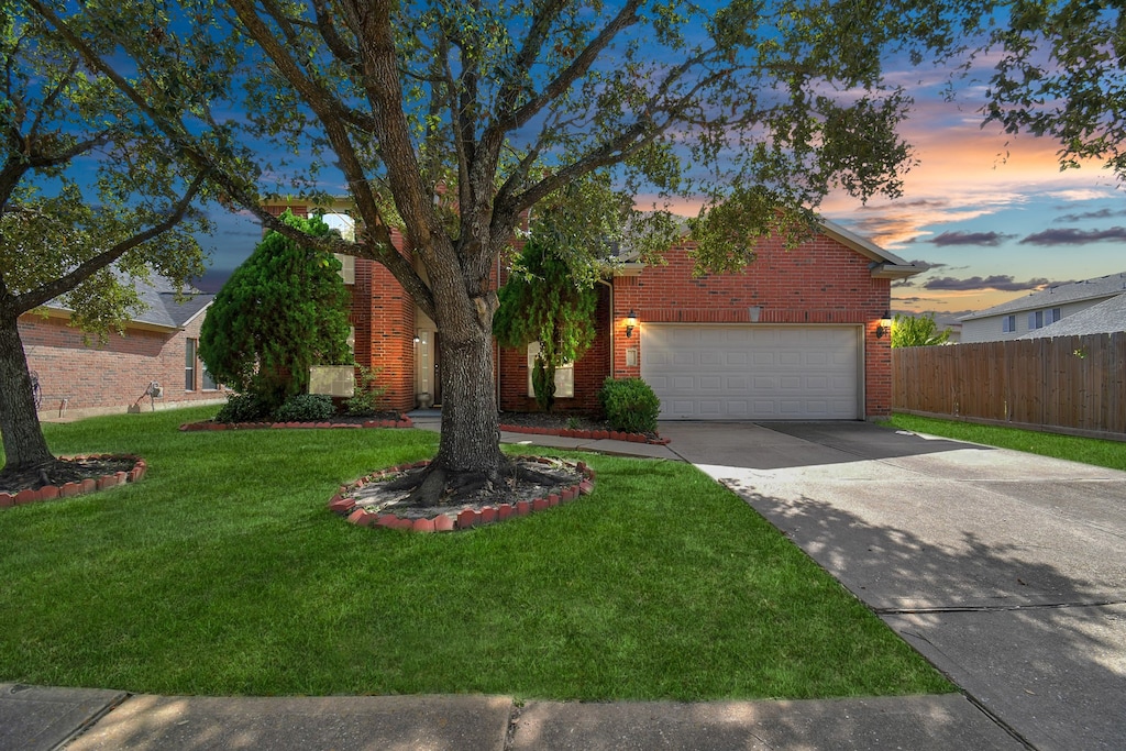 view of front of home with a yard and a garage