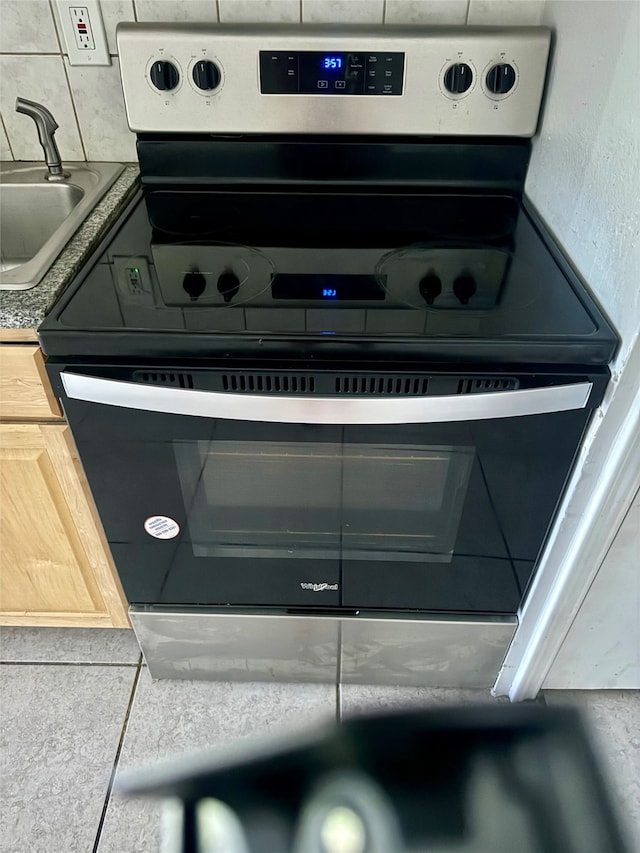 details featuring electric stove and sink