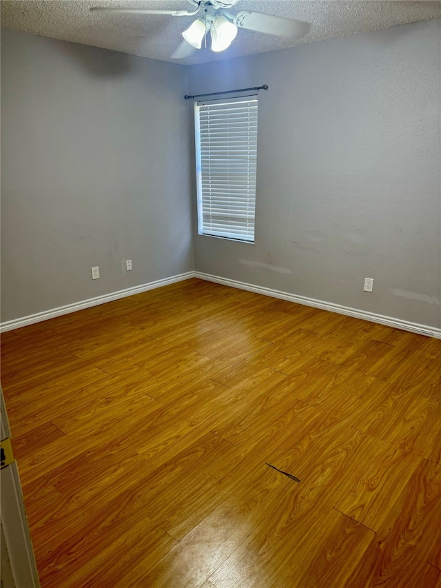 empty room with a textured ceiling, hardwood / wood-style flooring, and ceiling fan