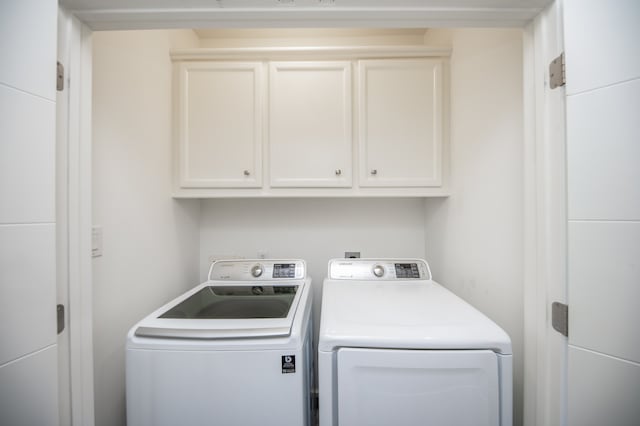 washroom featuring cabinets and washing machine and dryer