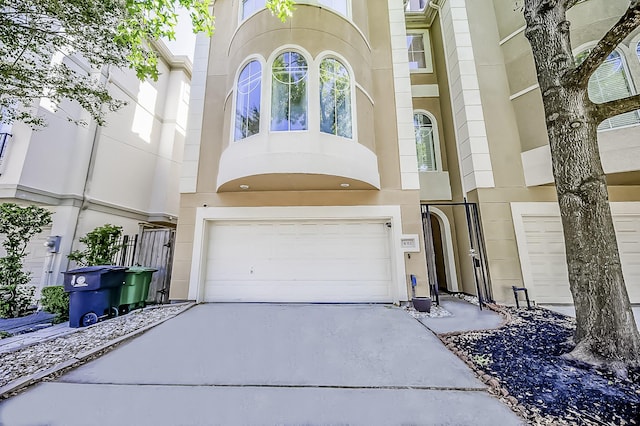 view of front of property featuring a garage, concrete driveway, and stucco siding