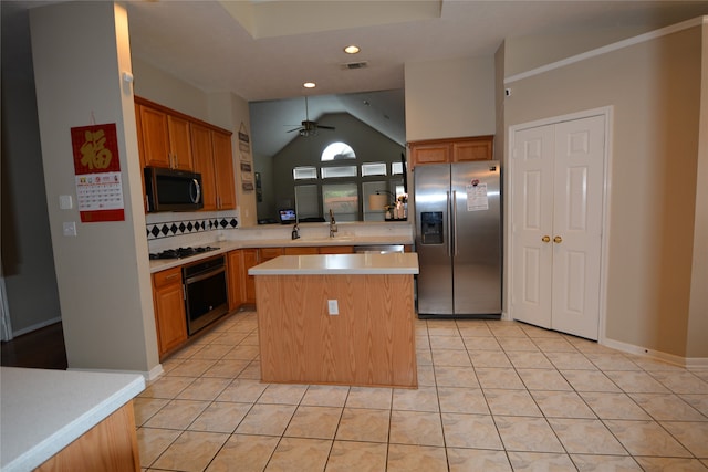 kitchen with ceiling fan, stainless steel appliances, light tile patterned floors, and a kitchen island